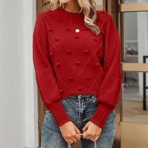 Detailed view of red crew neck sweater featuring decorative pom-poms and V-texture