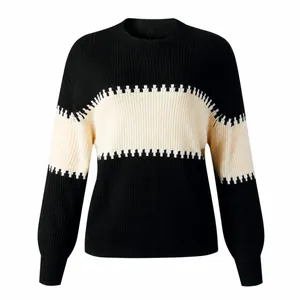 Detailed view of a women's black and cream color-blocked knit sweater with lantern sleeves