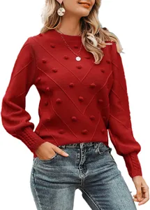 Detailed view of red pom-pom knit sweater with elegant round neck and long sleeves.