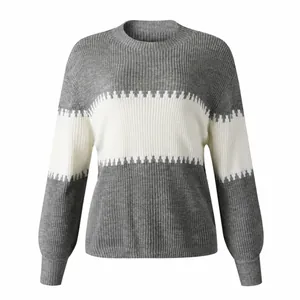 Close-up detail of a grey and white color-block sweater featuring lantern sleeves and crew neck