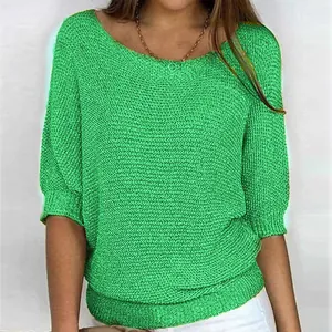 Close-up of vibrant green knitted top with three-quarter sleeves and texture