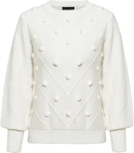 Detailed view of white knit sweater featuring decorative pom-poms and ribbed cuffs