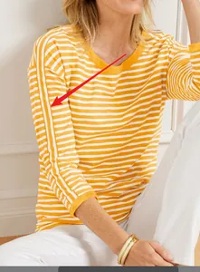 Detailed macro view of yellow striped knit sweater with vertical arm stripe accents.