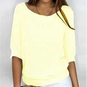 Detail view of a light yellow women's knit top with elegant round neck and 3/4 sleeves.
