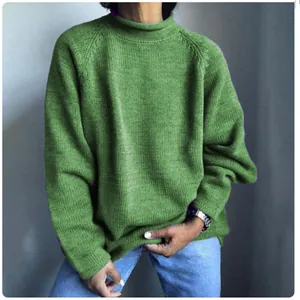 Dettaglio di un maglione verde oversize da donna in maglia con vestibilità comoda