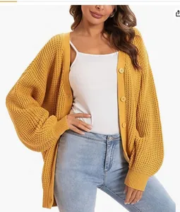 Detailed view of a chunky knit yellow cardigan with single-breasted buttons on a model.