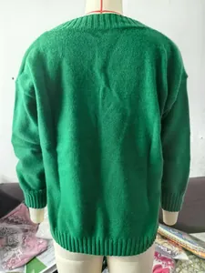 Detailed back view of a casual loose green knitted sweater displayed on a mannequin.