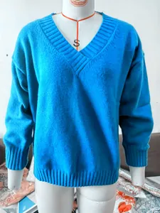 Detail view of a loose-fit blue knit sweater on a professional mannequin torso