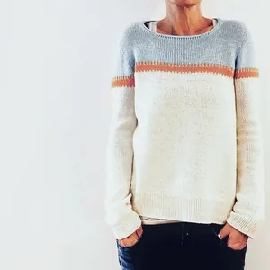 Detail shot of a women's tricolor knit sweater with light blue, orange and cream color blocking