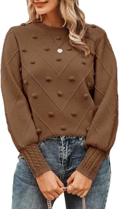 Close-up detail view of brown pom-pom knitted sweater with crewneck and chevron pattern