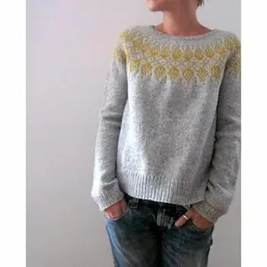 Detailed macro shot of a gray knitted pullover featuring a yellow patterned yoke collar