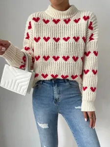 Detail view of cream knit sweater with red heart patterns and stylish loose fit