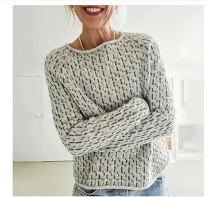 Close-up of women's round neck loose knit sweater with gray vertical speckled pattern.