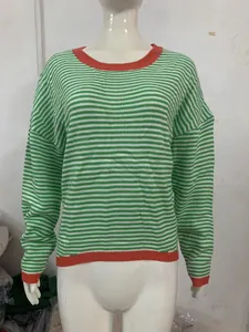 Detailed shot of a green and white striped knit sweater with orange contrast trim and drop shoulders