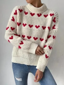 Detailed view of women's white chunky knit sweater with vibrant red heart jacquard pattern.