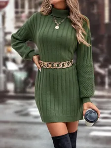 Close-up detail of olive green turtleneck ribbed knit mini dress with gold chain belt