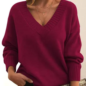 Close-up of a burgundy V-neck oversized knit sweater showing soft ribbed texture.