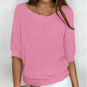 Close-up detail of a pink elegant knit top with a boat neck and 3/4 sleeves on a model.