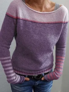 Close-up of stylish women's color-block knitted sweater with striped sleeve details