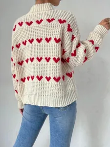 Detail of the back side of a white knit sweater with a red heart jacquard design.