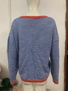 Back view of blue white striped knit sweater with orange contrast hem and neckline.