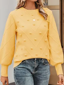 Elegant women's yellow knit sweater with stylish pom-pom details and chevron texture pattern