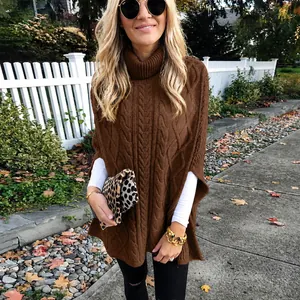 Elegante bruine kabelgebreide coltrui poncho voor dames in een herfstige buitenomgeving.