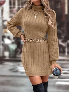 Detailed view of a khaki turtleneck knitted sweater dress with a gold chain belt