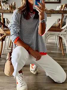Chic striped knit sweater with orange contrast trim and drop shoulder for a casual look.