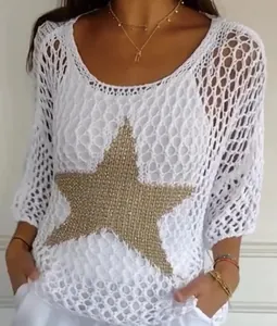 Detail of white crochet knit top featuring a large gold star and 3/4 sleeves.