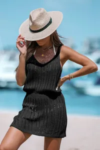 Detail view of a black sleeveless knit mini dress with hollow-out pattern for resort wear