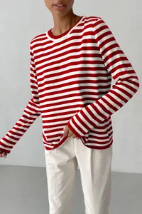 Detailed view of a red and white horizontal striped crew neck knit sweater on model