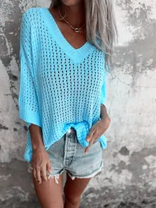 Close-up detail of light blue hollow-out knit sweater with V-neck design and loose fit style