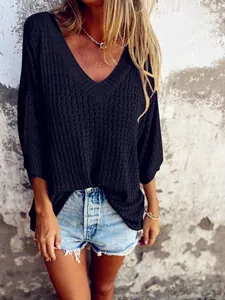 Detailed view of a black hollow-out knit sweater featuring a stylish V-neck design.