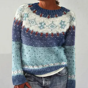 Dettaglio di un maglione a maglia da donna con motivi geometrici blu e bianchi