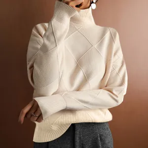 Close-up detail of a cream turtleneck knit sweater featuring a textured diamond pattern