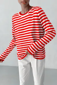 Detailed view of women's red and white horizontal striped crew neck knit sweater on model