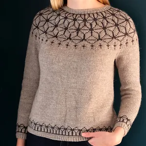 Dettaglio di un maglione lavorato a maglia beige Fair Isle con motivi geometrici scuri