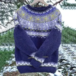 Vista dettagliata del motivo Fair Isle sul maglione a maglia viola in una foresta innevata