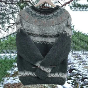 Dettaglio del maglione lavorato a maglia da donna con motivo nordico in un bosco innevato