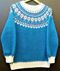 Dettaglio del motivo nordico su un maglione a maglia blu con scollo a girocollo