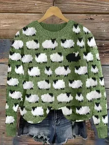Dettaglio del maglione in maglia verde con motivo a pecore bianche e nere iconico