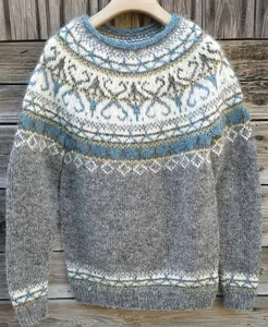 Vista dettagliata di un maglione grigio in stile nordico con motivi blu e bianchi