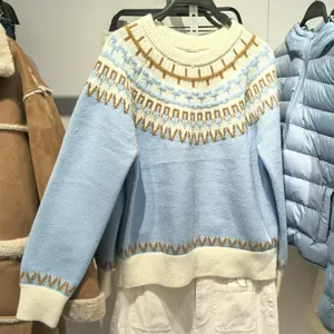 Maglione da donna in maglia blu e bianca con motivi geometrici nordici su un appendino