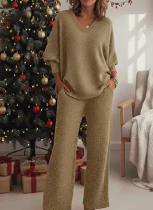 Close-up of elegant golden glittery two-piece V-neck sweatshirt and wide-leg pants set