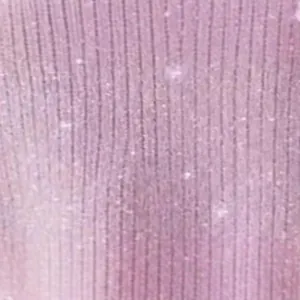 Macro detail of pink long sleeve T-shirt fabric with shiny silver thread texture