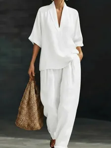 Detailed shot of woman wearing a white V-neck short sleeve top and wide leg pants set
