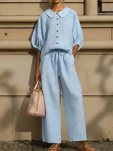 Detail of a light blue cotton linen set featuring a lantern sleeve shirt and wide-leg pants
