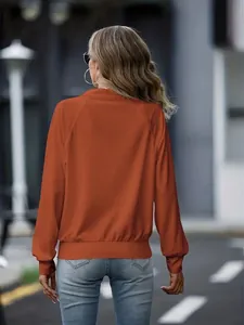 Πίσω όψη μιας casual γυναικείας πλεκτής ζακέτας σε χρώμα σκουριάς σε εξωτερικό χώρο