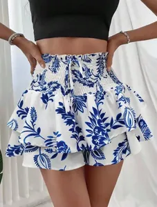 Detailopname van een blauw-witte bloemen gelaagde skort met hoge elastische taille.